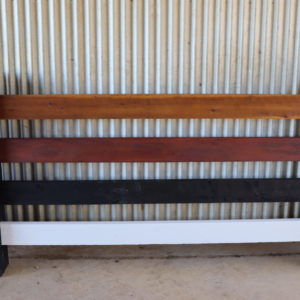 photo of post and rail fence panel with four panels, each finished in different oil, paint or stain.