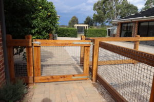 photo of two rail timber post and rail fence with metal mesh fill, finished in natural linseed oil, by Saltram Rural